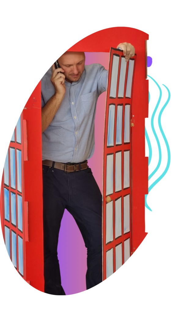 Victoria Instituto Bilingüe teacher in a red British phone box on a mobile phone
